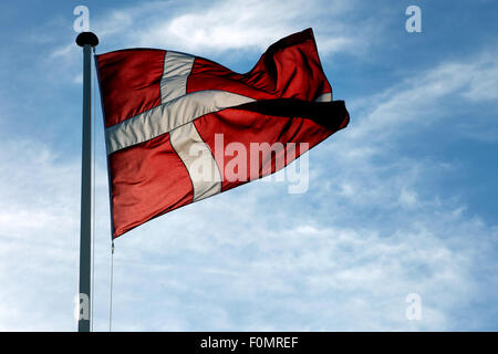 The Danish flag Dannebrog waving against blue sky