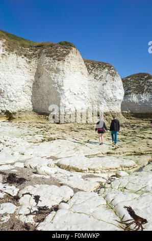People walking across the chalk rocks at Flamborough head UK Stock Photo