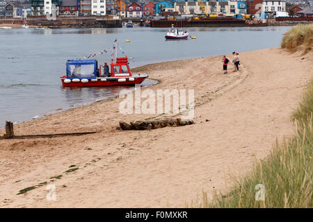 Passengers alighting from 'water taxi' at Dawlish Warren. Boat picking up passengers for return trip to Exmouth (in background). Stock Photo