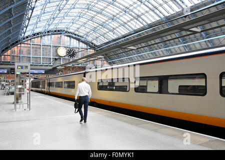 Departing lone traveller makes his way along St Pancras International Station platform to his reserved Eurostar carriage seat Camden London England UK Stock Photo