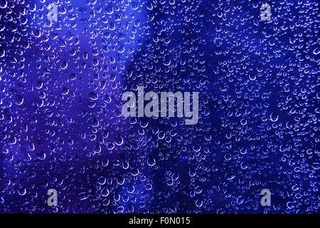 Blue Water Beads Background. Blue Wet Glass Photo Backdrop. Stock Photo