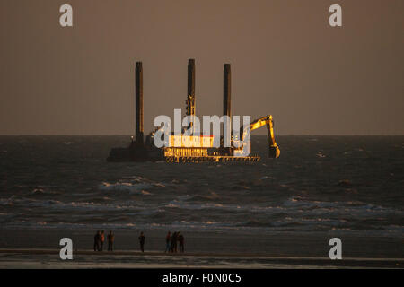 Blackpool, UK. 18th August, 2015. UK weather. After a cloudy day in Blackpool, plenty of work still to be done on the outflow pipe at south beach the last golden rays of the setting sun can be seen illuminating the working vessel Credit:  gary telford/Ģ����ý Live News Stock Photo