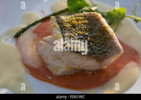 Closed up of cooked Sea Bream fish with vegetables on white plate Stock Photo