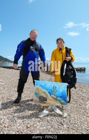 Lake Baikal, Siberia, Russia. 15th Oct, 2014. Underwater artist Yuriy Alexeev (Yuri Alekseev) and his assistant standing next to the picture painted in the water. drawing pictures under water. © Andrey Nekrasov/ZUMA Wire/ZUMAPRESS.com/Alamy Live News Stock Photo