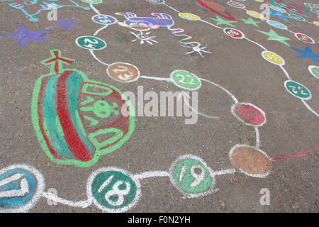 childish drawings as a game on the asphalt of street Stock Photo