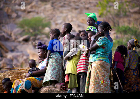 Unidentified Group of african people, kids, and women, watching a festival of music and dance on the roof of a house in the Dogo Stock Photo