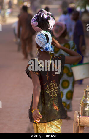 unrecognizable woman seen from the back  walking in the street of Mopti dressed with wonderful local fabrics.2010 Stock Photo