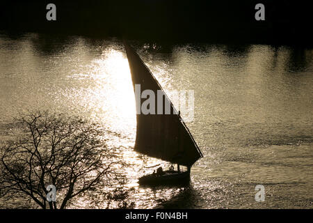 Faluka boat on nile against afternoon sun in Egypt Stock Photo