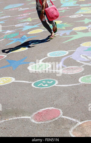 child jumping on the childish drawings as a game on the asphalt Stock Photo