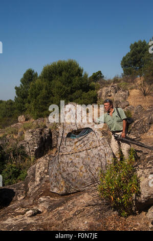 Photographer, Pete Oxford, next to hide, Sierra de Andújar Natural Park, Mediterranean woodland of Sierra Morena, north east Jaén Province, Andalusia, Spain, May 2009 Stock Photo
