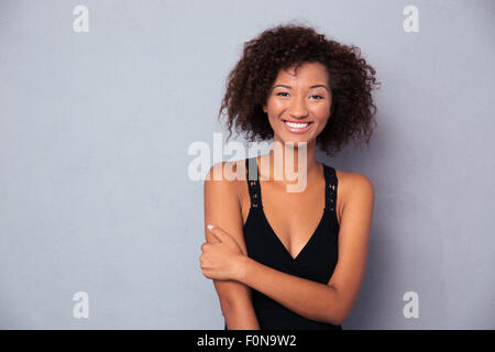 Portrait of a happy black african woman standing over gray background Stock Photo
