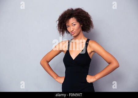 Portrait of a serious african woman standing over gray background and looking at camera Stock Photo