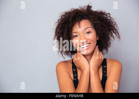 Portrait of a cheerful afro american woman standing over gray background Stock Photo