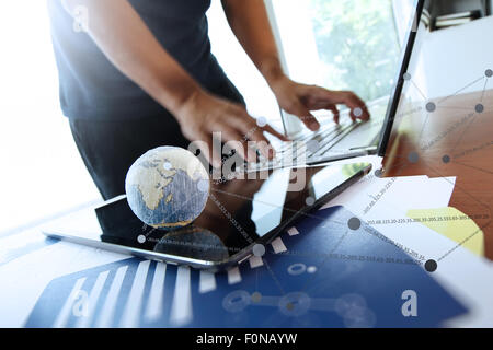 business documents on office table with texture the world on digital tablet and man using smart phone in the background Stock Photo