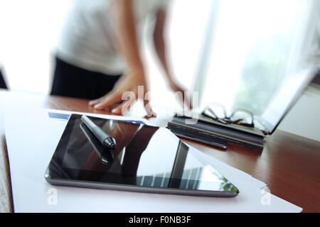 business documents on office table with texture the world on digital tablet and man using smart phone in the background Stock Photo