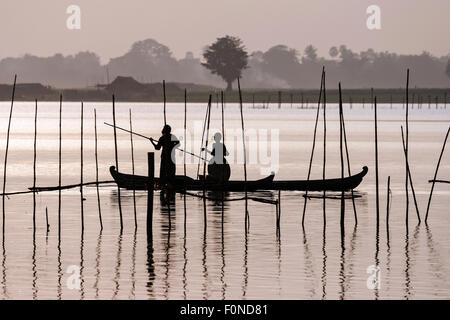 Two people standing in a dugout canoe, backlight, Taungthaman Lake, Amarapura, Division Mandalay, Myanmar Stock Photo