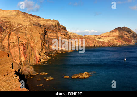 Rocky coast, Ponta de Sao Lourenco with a sailboat in the bay, Caniçal, Madeira Island, Portugal Stock Photo