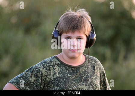 Boy teenager listening to music with headphones on nature Stock Photo