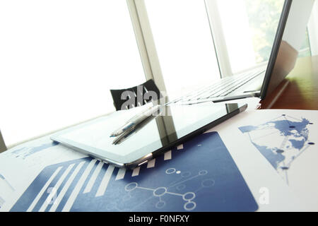 business documents on office table with texture the world on digital tablet and man using smart phone in the background Stock Photo