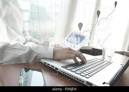 business documents on office table with smart phone and digital tablet and man working in the background Stock Photo