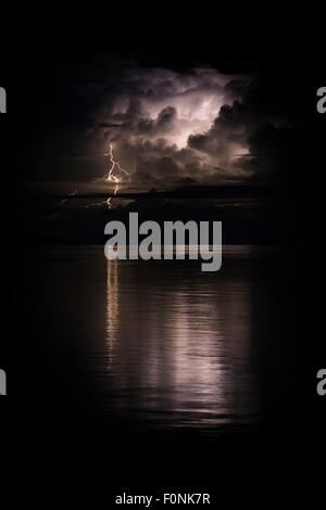 Lighting on the horizon reflected in the ocean in Indonesia, Asia. Stock Photo