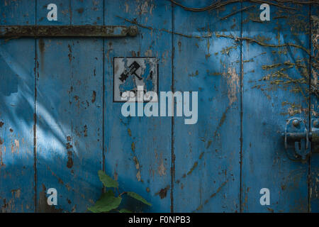CCTV warning sign pictogram on light faded old door. Stock Photo