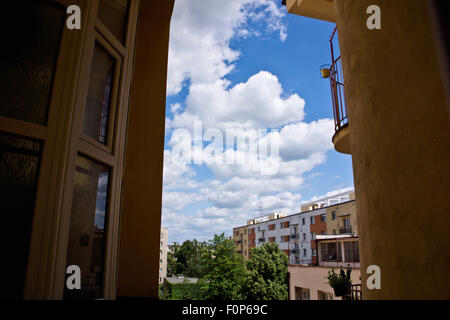 blue sky with white clouds between residential buildings Stock Photo