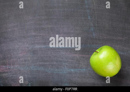 Green apple on blackboard or chalkboard background. Top view with copy space Stock Photo