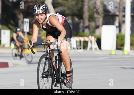 Smiling Female Cyclist Competing In The Long Beach Triathlon. 16 August 2015. Stock Photo