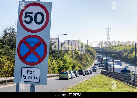 50 mph speed limit sign and a No Stopping road sign with traffic congestion on the A454, Black Country Route, Bentley, West Midlands, England, UK Stock Photo