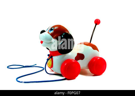 Old toy plastic dog with wheels isolated on white Stock Photo