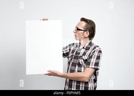 Man in eyeglasses and tartan shirt displaying a white board Stock Photo