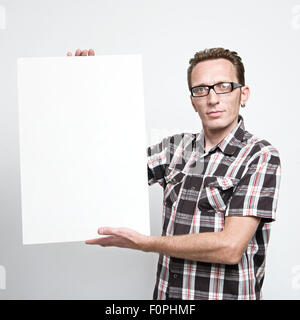 Man in eyeglasses and tartan shirt displaying a white board Stock Photo
