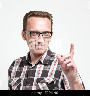 Handsome man in eyeglasses and tartan shirt put his index finger up. Concept of the idea or warning, Stock Photo