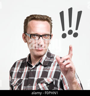 Handsome man in eyeglasses and tartan shirt put his index finger up to exclamation mark. Concept of the idea or warning, Stock Photo