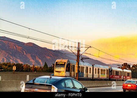 A Los Angeles Metro Rail train along the 210 freeway near Pasadena California in the golden light of sunset. Stock Photo