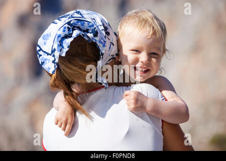 Happy toddler boy embracing mother and laughing Stock Photo