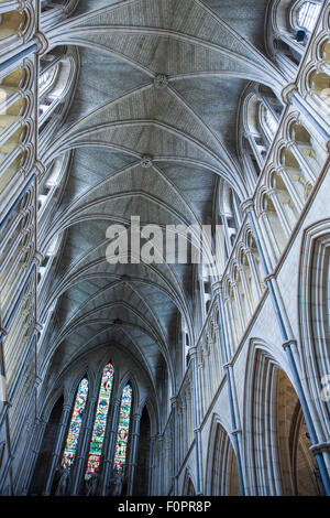 Vaulted roof and ceiling at Southwark Cathedral with columns arches and stained glass windows at this historic London building