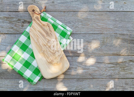 Empty wooden garden table with cutting board over tablecloth. Top view with copy space Stock Photo