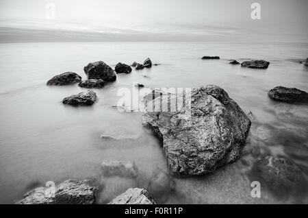 black and white photo of stones on the beach. rocks on the coast Stock Photo