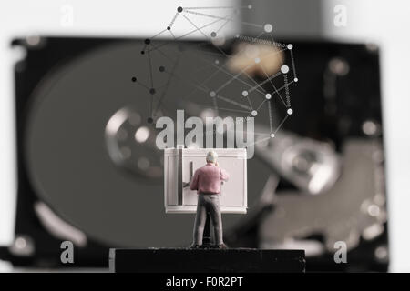 Close up of open computer hard disk drive with social network diagram on desk and notebook Stock Photo