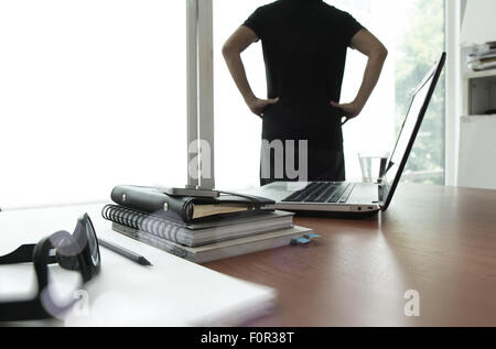 business documents on office table with texture the world on digital tablet and man using smart phone in the background Stock Photo