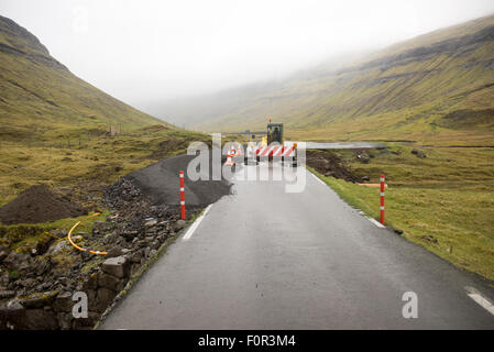 Road construction site on the Faroe Islands with road block sign and digger Stock Photo