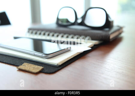 business documents on office table with texture the world on digital tablet and man using smart phone in the background Stock Photo