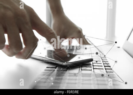 Businessman hand using laptop and mobile phone in office Stock Photo