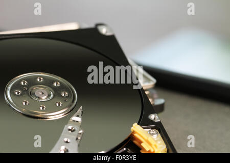 Close up of open computer hard disk drive on desk and notebook Stock Photo