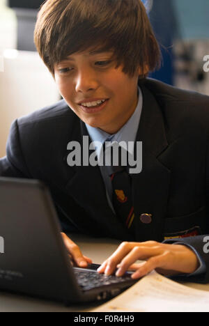 Secondary school pupil using laptop computer in class, Surrey, UK. Stock Photo