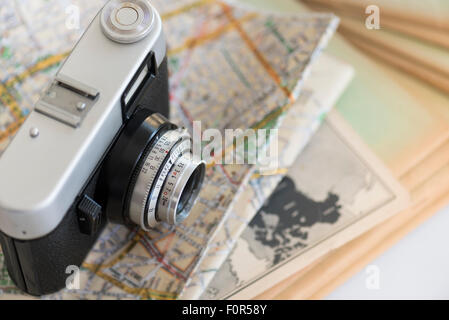 35mm vintage photocamera on book and travel map Stock Photo