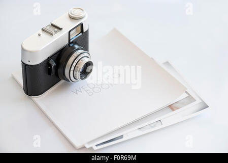 35mm vintage photocamera on wedding book with print Stock Photo