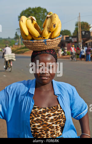 Ugandan woman with Bananas on head posing for camera, Uganda, Africa Stock Photo